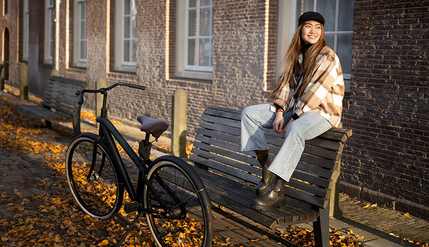 Fietsende vrouw in groene omgeving – symbool voor duurzame keuzes Vrouw fietst door groene omgeving als symbool voor duurzame levensstijl